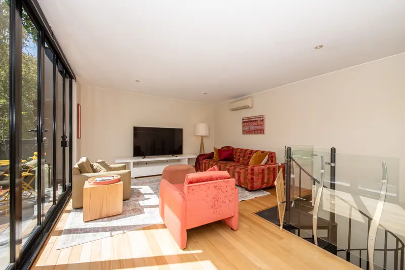 Living room with polished timber floors opening onto the north-facing terrace