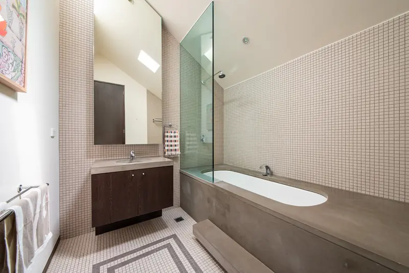 Main bathroom with stone-clad soaker tub and mosaic tiling