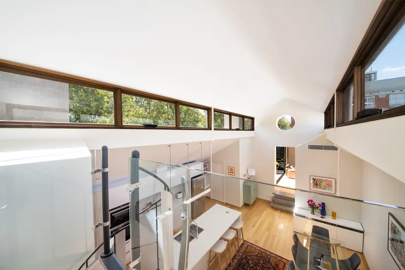 Mezzanine home office with glass balustrade, washed in clerestory light